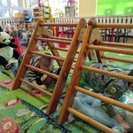 Dzieci ćwiczą czworakowanie pod podwójnymi drabinkami gimnastycznymi z misiami.
