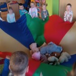dzieci trzymają chustę animacyjną klanzy_ na środku leżą misie.