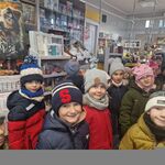 dzieci w urzędzie pocztowym_ dorosła osoba przed okienkiem_ wysyłą kartki.