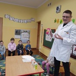 Farmaceuta pokazuje dzieciom różne lekarstwa.