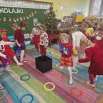 Na dywanie leżą małe obręcze_ dziewczynki z worecczkami w ręku skaczą z obręczy na obręcz.