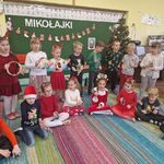 Dzieci z instrumentami w ręku stoją lub siedzą w półkolu.