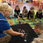 Dzieci przyglądają się guzikom pokazywanym przez panią.