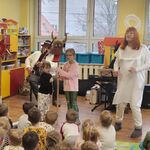 Dwie dziewczynki trzymają Turonia_ w tle siedzą muzycy.