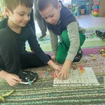 Dwaj chłopcy ustawiają dinozaury na kratownicy