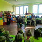 Dziewczynka w opasce kaczki naśladuje jej mowę.