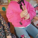 dziewczynka trzyma w ręku mini narzędzia ogrodnicze.