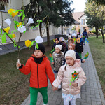 Dzieci z kwiatami i gaikiem wychodzą z przedszkola_ aby powitać pierwszy dzień wiosny.
