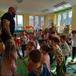 Trener obserwuje jak przedszkolaki ćwiczą stanie na jednej nodze.