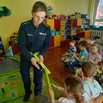 Pani policjantka rozdaje przedszkolakom odblaski.