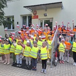 dwie grupy dzieci stoją na schodach trzymając w rękach biało-czerwone chorągiewki.