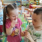 Dwoje dzieci trzyma przynęty na ryby.