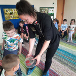 Pani Aneta pokazuje dzieciom kwiat  zrobiony w galaretce.