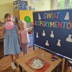 Dwie dziewczynki trzymają balony przekłute patykiem.