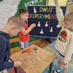 Trzech chłopców sprawdza siłę róznych magnesów.