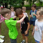 Chłopiec zawiesza koledze na szyję medal.