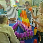 14 Kilku chłopców buduje wieżę z kolorowych kubeczków.jpg