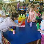 11 Dzieci przy kilku stolikach stawiają budowle z kolorowych kubeczków.jpg