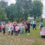 Animatorka zabawia dzieci które rzucała małe piłki w gorę