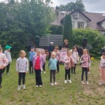 Dzieci ustawione w dwuszeregu przygotowują się do tańca, z boku stoi instruktor tańca Pani Ewelina