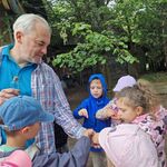 Dzieci biorą z dłoni dorosłego ziarna przypraw.