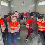 dzieci siedzą w wozie do transportu osób.