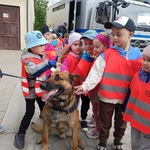 Kilkoro dzieci głaszcze psa.