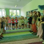Dzieci stoją naprzeciwko pań i pokazują rękami określone gesty.