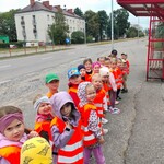 dzieci w parach oglądają znak drogowy  - przystanek autobusowy.
