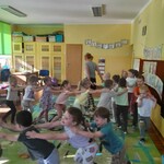 sala przedszkolna_ dzieci tańczą ustawione w pociąg.