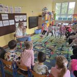 Chłopczyk przytulony do mamy siedzi naprzeciwko dzieci.