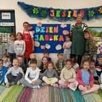 Grupa dzieci z dwiema paniami pozuje przy napisie Dzień jabłka.
