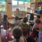 Pani bibliotekarka prezentuje dzieciom teatrzyk kamishibai.