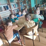Dzieci siedzą przy stoliku w czytelni