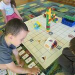 Chłopiec programuje Genibota_ dziewczynka siedzi obok i obserwuje.