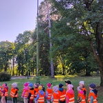 grupa przedszkolaków ustawiona w pary _ w tle park i latarnia.