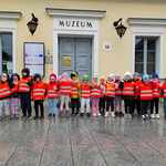 dzieci ubrane w kamizelki bezpieczeństwa ustawione przy wejściu do muzeum.