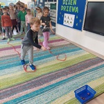 Dzieci stoją w dwóch rzędach, dwoje dzieci idzie po linii trzymając kasztan na łyżce 