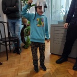 Chłopiec stoi w hełmie trzymając miecz.