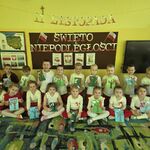 Dzieci ustawione są przy tablicy tematycznej_ trzymają w rękach obrazki biało - czerwonego drzewa.