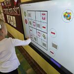 Dziewczynka układa patriotyczne sudoku na tablicy multimedialnej.