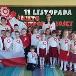 Dzieci z grupy IV wraz z Paniami stoją przed napisem Święto Niepodległości 
