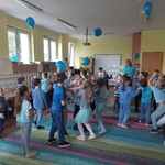 Dzieci tańczą z niebieskimi balonami 