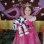 Dziewczynka w stroju księżniczki prezentuje robota.