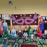 Dzieci przebrane w balowe stroje pozują ze swoimi robotami.