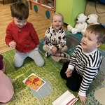Dzieci układają puzzle na dywanie.