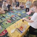 Dziewczynka wkłada miśka - żelka do kubeczka z colą.