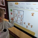 Dziewczynka układa sudoku na tablicy multimedialnej.