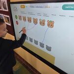 Chłopiec rozwiązuje misiowe zadanie na tablicy multimedialnej.