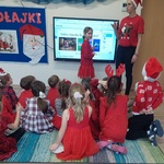 Dziewczynka stoi przy tablicy multimedialnej i rozwiązuje guiz